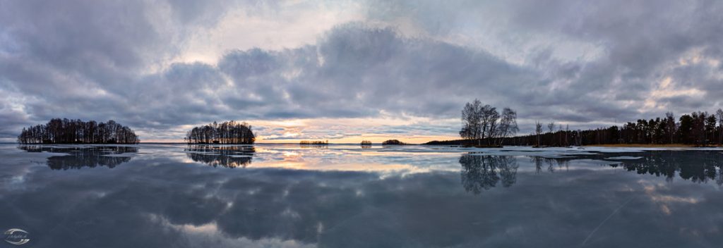 Panorama eines gefronenen Sees mit einem bewölkgem Himmel