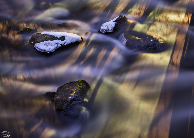 Schneebedeckte Steine in einem Fluss