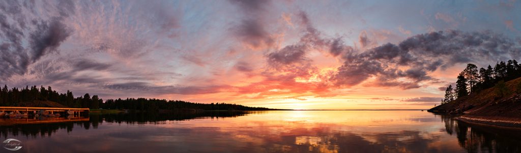 Panorama eines Sees nach Sonnenuntergang mit Wolken am Himmel