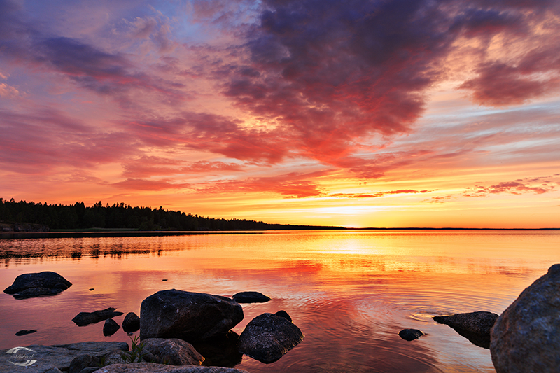 Panorama eines Sees nach Sonnenuntergang mit Wolken am Himmel