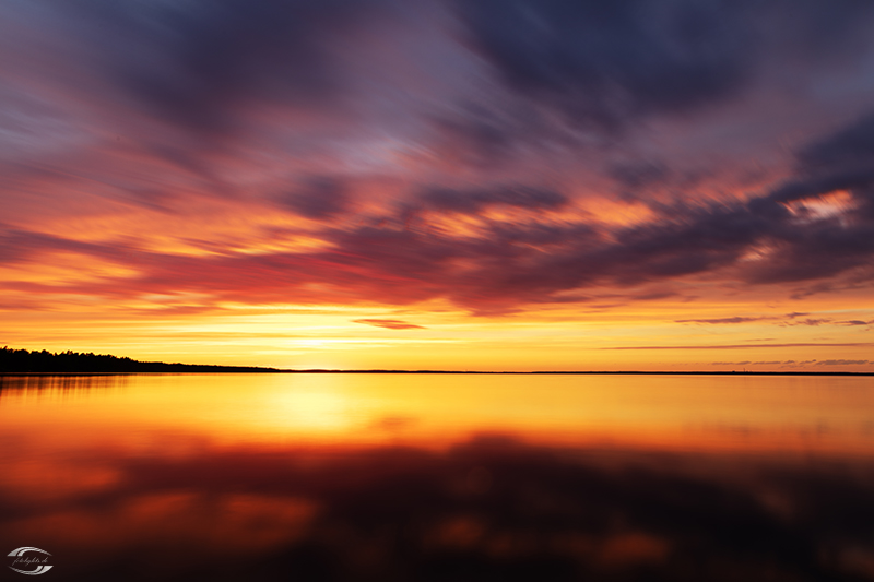 Wolken über einem See nach Sonnenuntergang