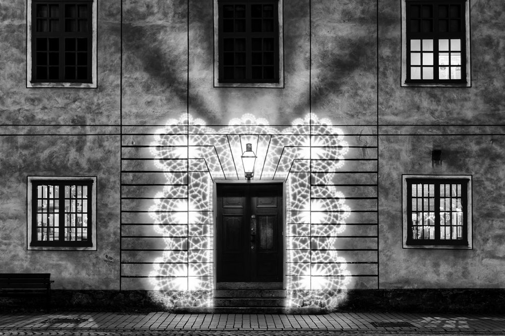 Blick auf den Eingang eines beleuchteten Gebäudes in schwarz-weiß