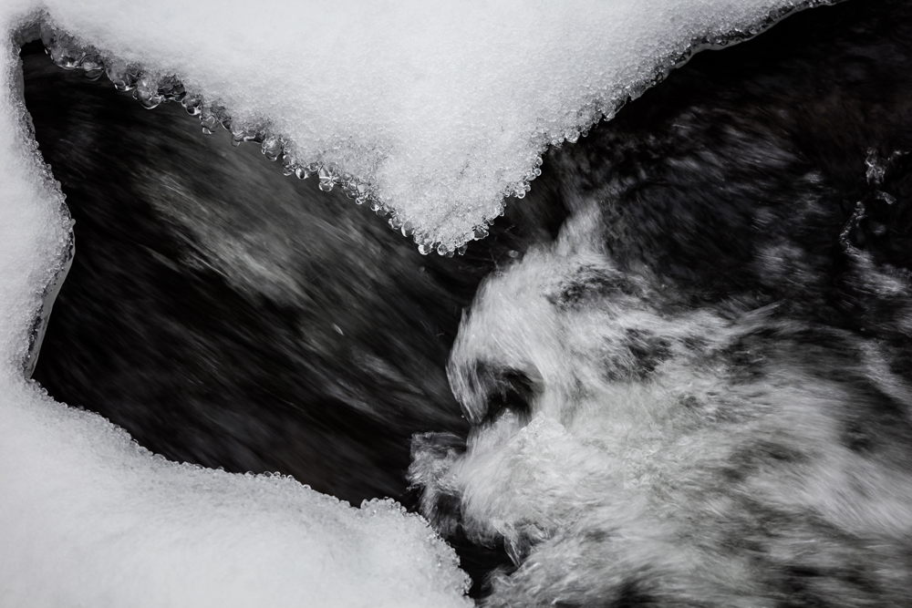 Mit Eis überzogene Steine in einem Fluss