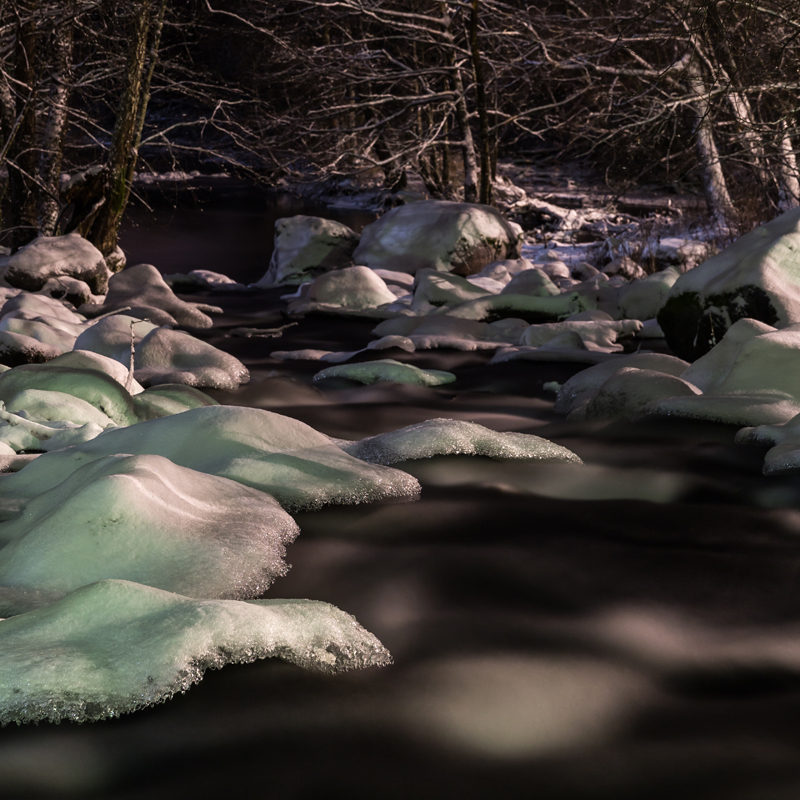 Mit Eis überzogene Steine in einem Fluss