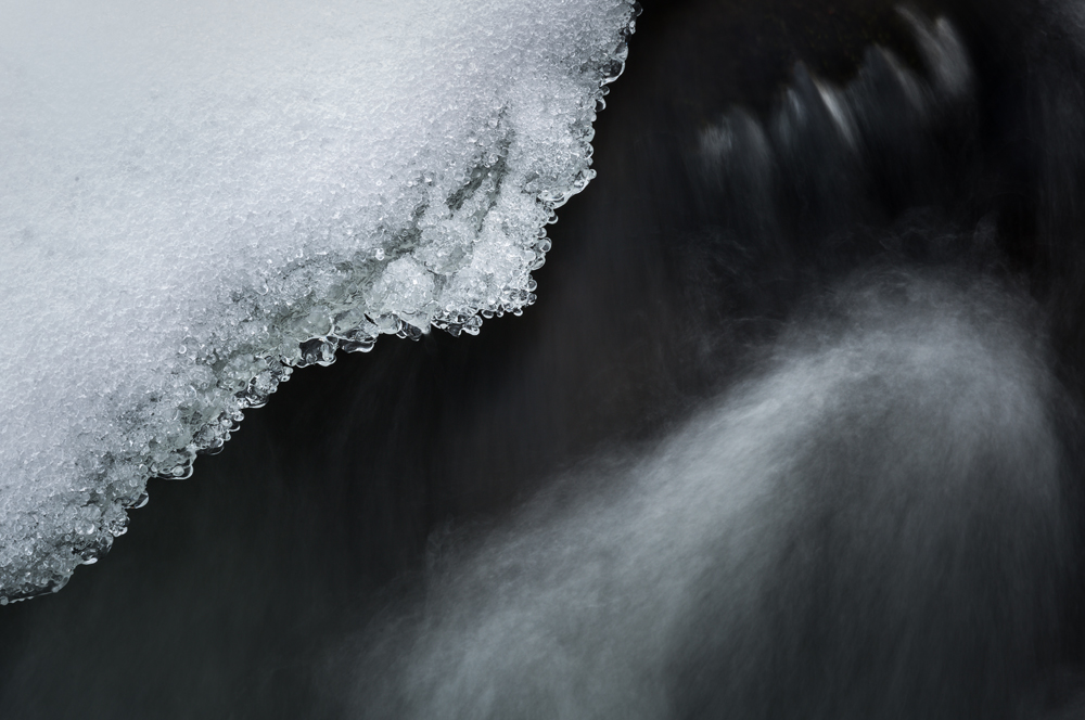 Mit Eis überzogene Steine in einem Fluss