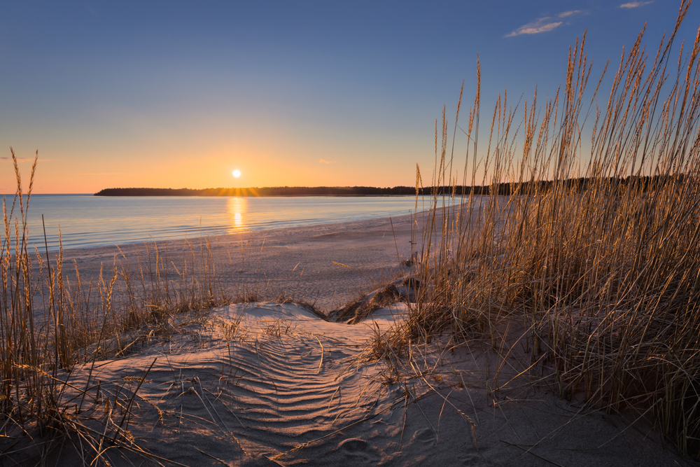 Blick einen Strand entlang bei Sonnenuntergang