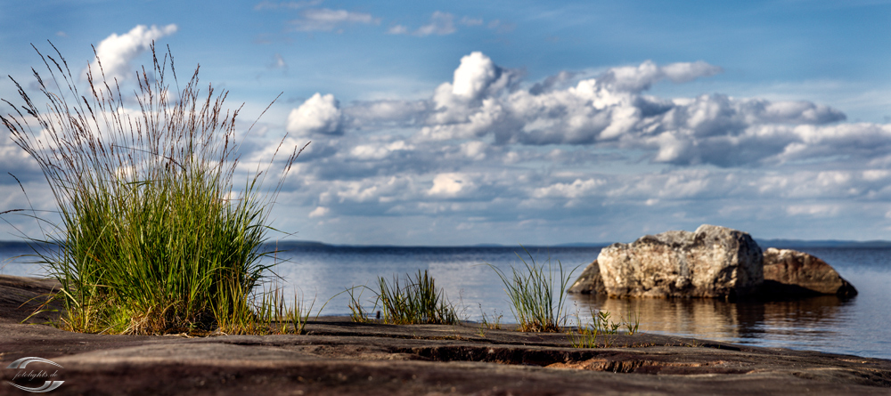 Blick über einen See mit Wolken am Himmel