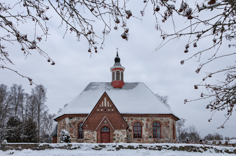 Blick auf eine verschneite Steinkirche