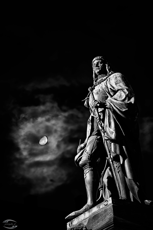 Statue mit Mond im Hintergrund in schwarz-weiß