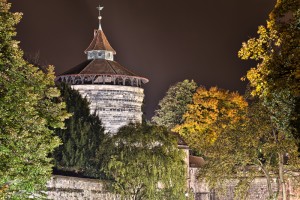 Blickk auf den Neutorturm im Herbst mit gefärbten Blättern nachts