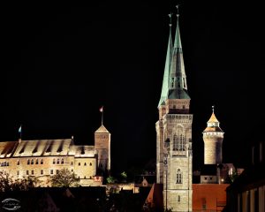 Türme der Sebalduskirche mit der Kaiserburg im Hintergrund bei Nacht